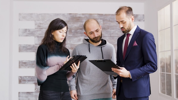 real estate agent business suit talking about finances with clients buy new apartment broker with clients empty apartment